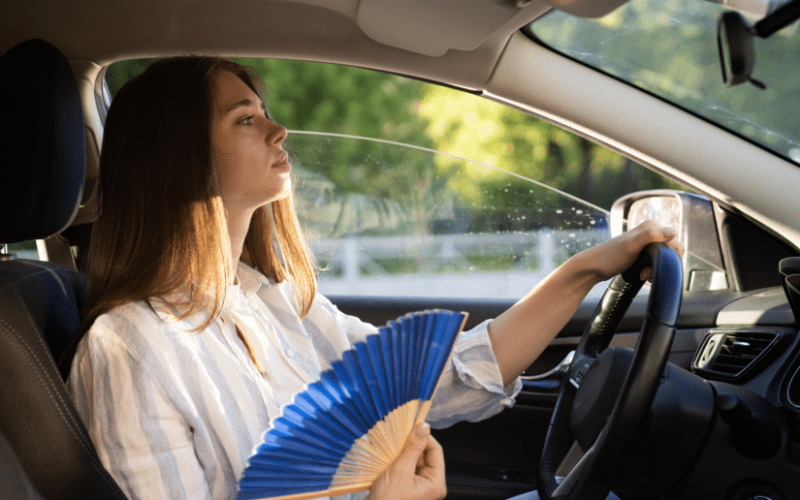 woman fanning inside the car